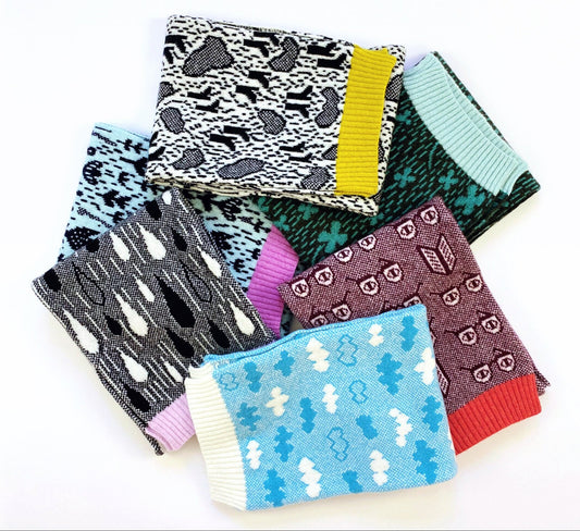Set of colorful knitted patterned scarves on a white background