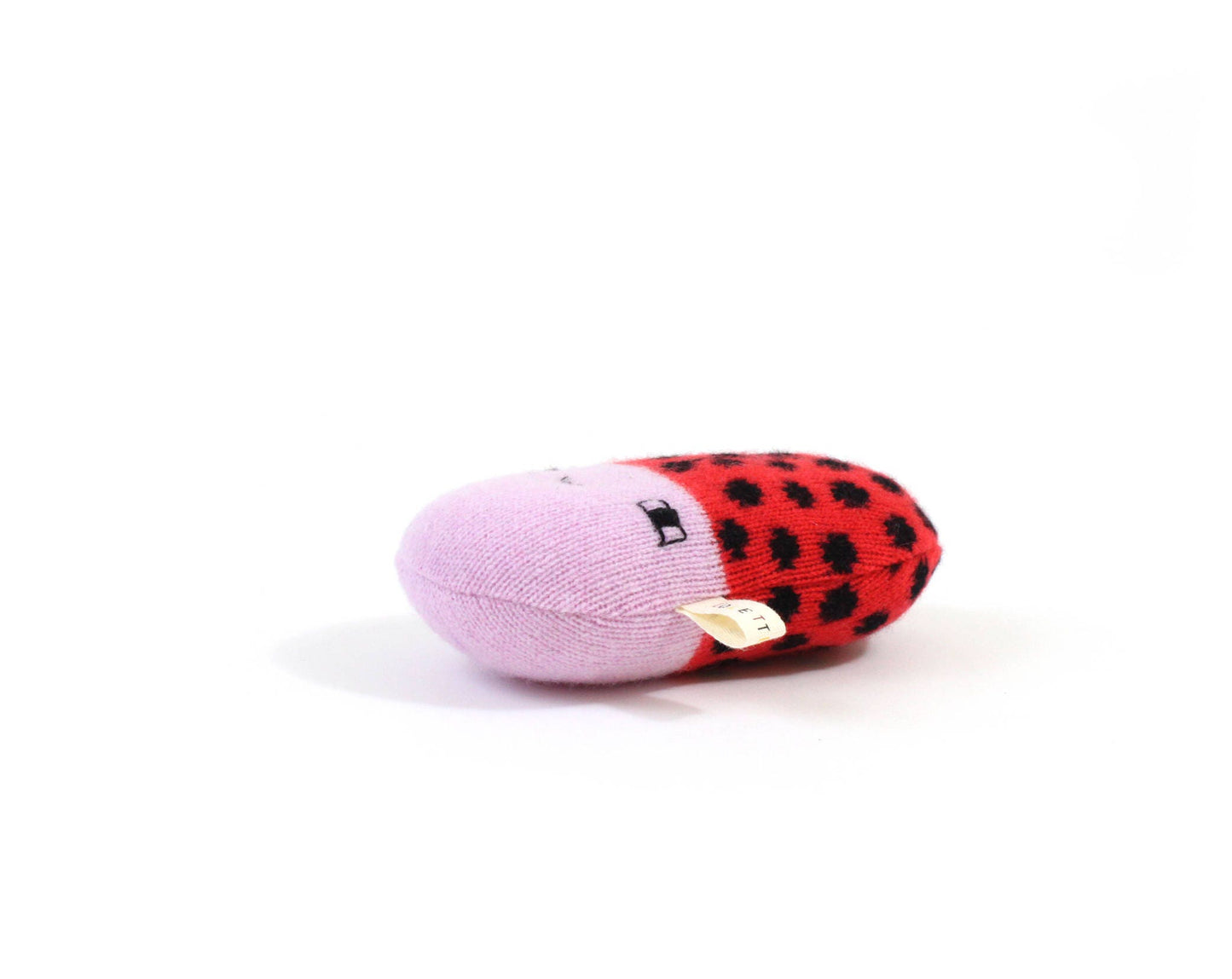 Soft knitted baby rattle plush toy shaped like a ladybug with a pink body and red shell on a white background