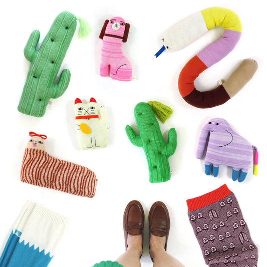 Colorful knitted plush toys shaped like animals and objects on a white background
