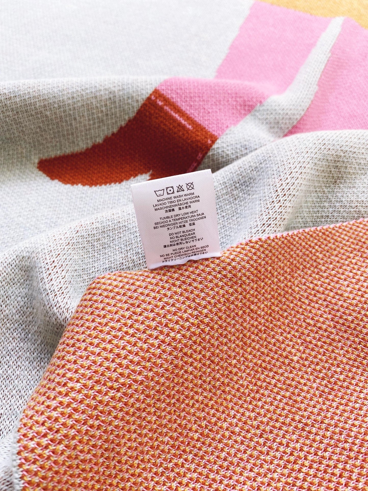 Close-up of a knit fabric with a label on a multicolored background