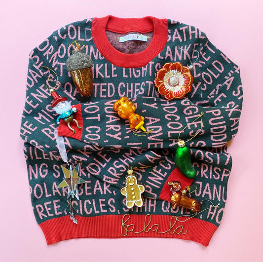 Knit holiday sweater with Christmas-themed decorations on a pink background