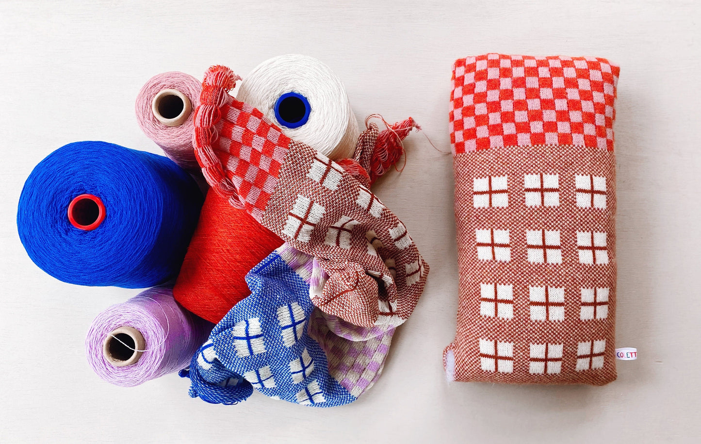 Collection of colorful yarn and fabric rolls on a white background