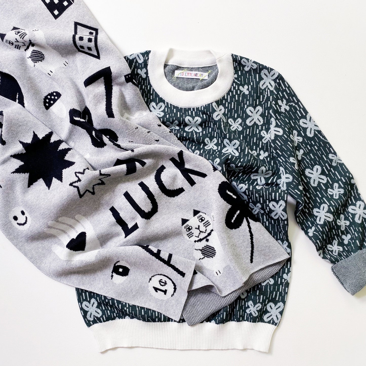 A sweaters and a blanket with patterned knitted designs on a white background