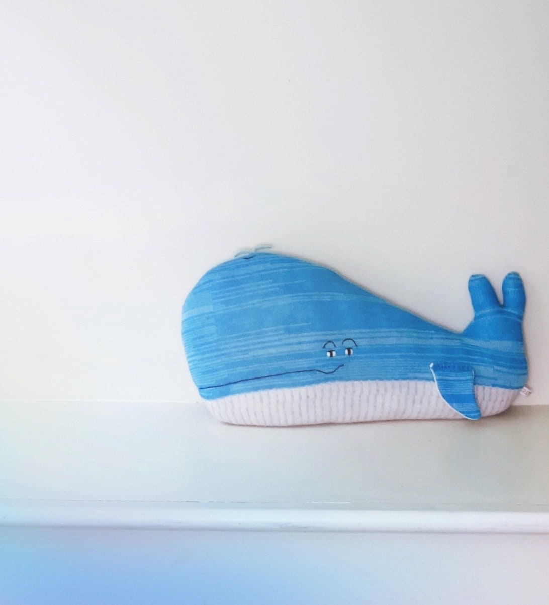 Blue whale-shaped pillow on a white background