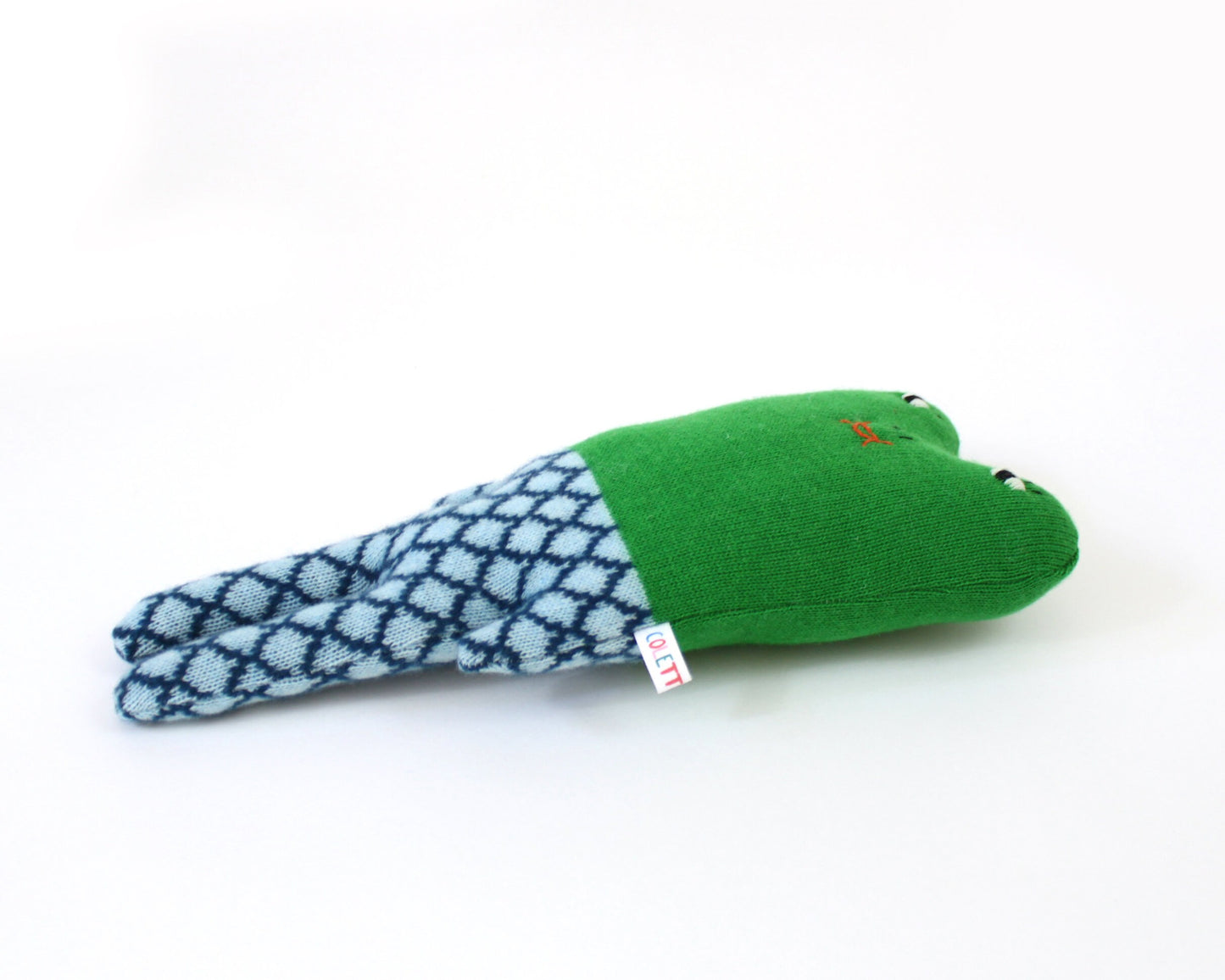 Green and blue knitted frog toy on a white background