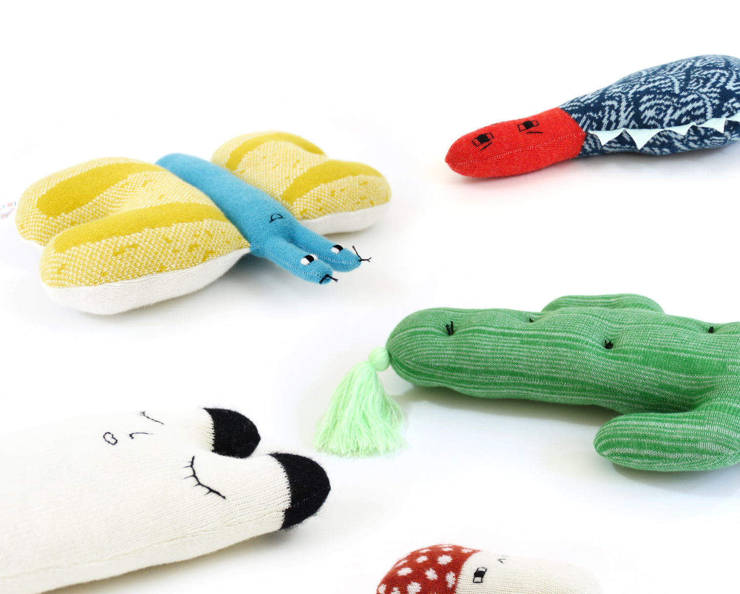 Collection of colorful animal-shaped knitted plush toys on a white background