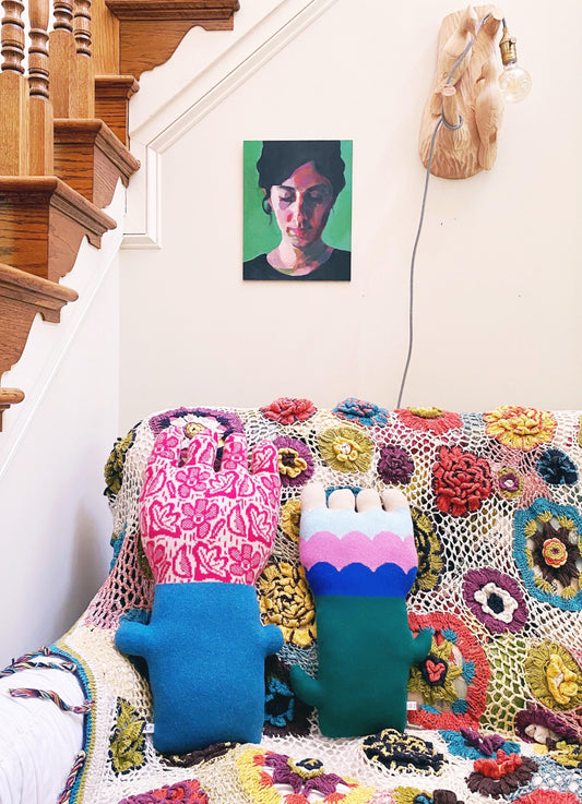 Colorful crocheted blanket with flower shaped cushions on a colorful sofa couch