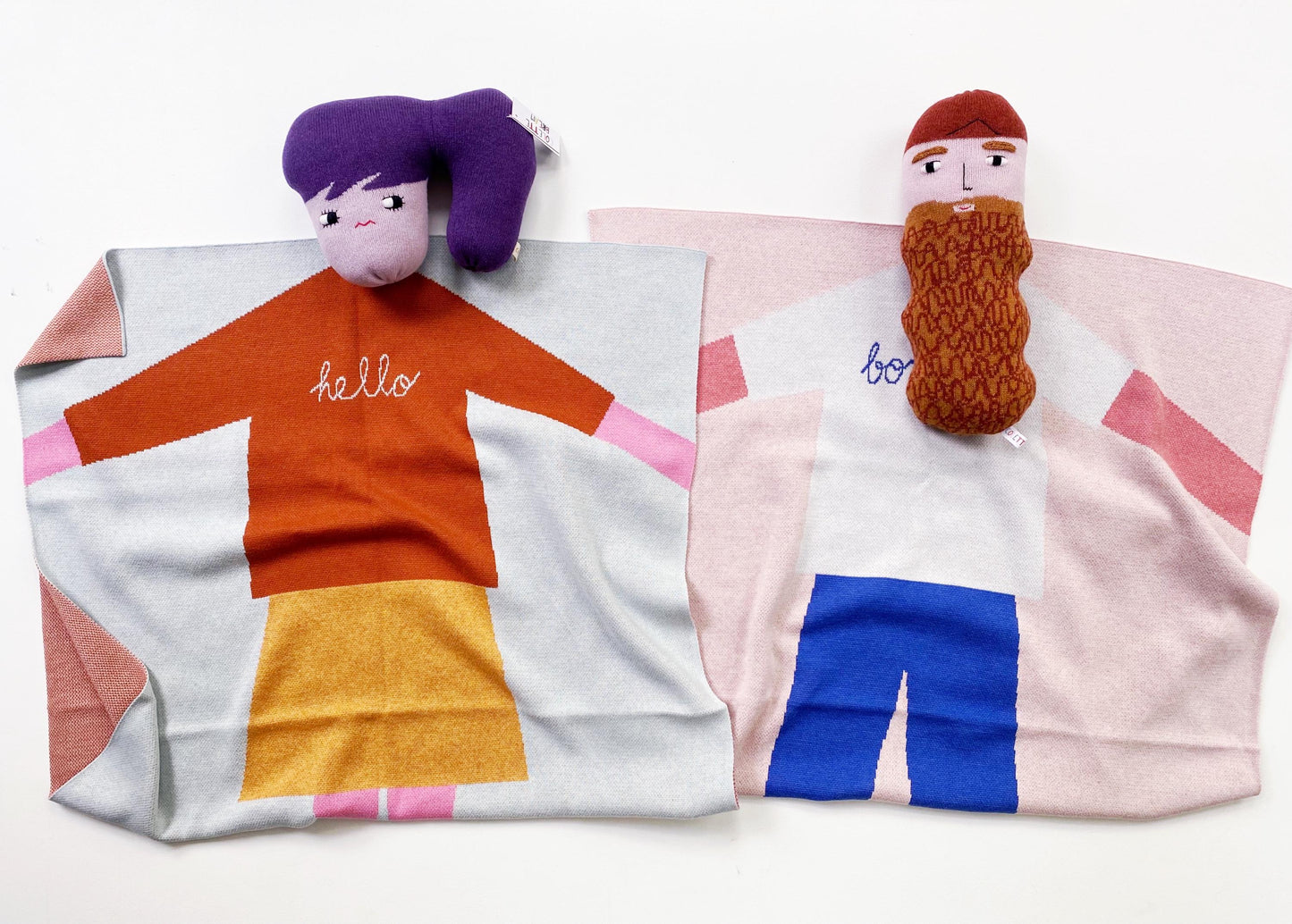 Two colorful plush toys on patterned knitted baby blanket backgrounds