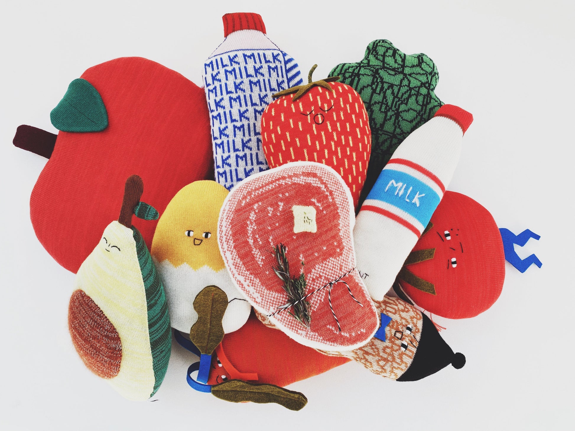 Colorful fabric toys shaped like fruits and vegetables on a white background