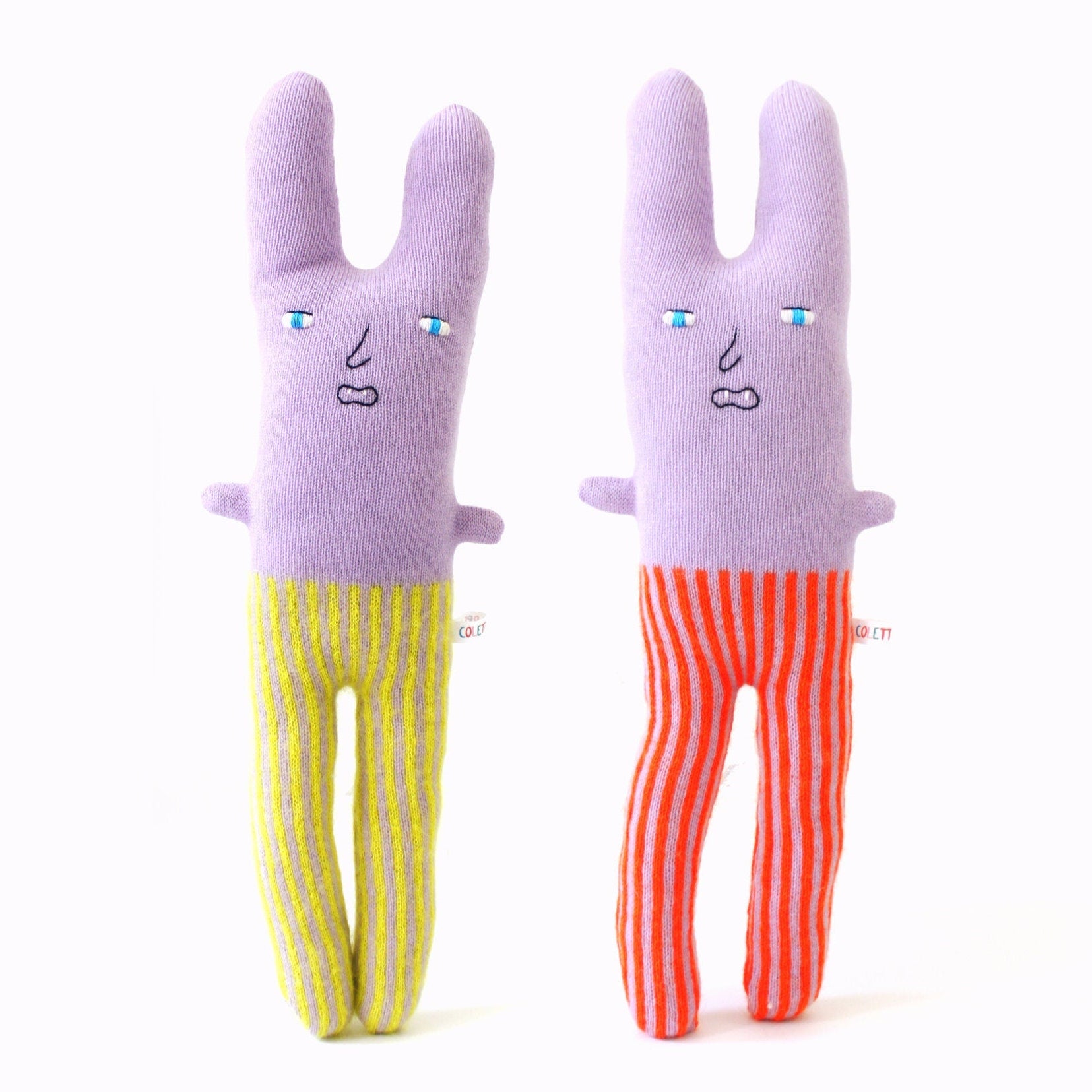 Two lambswool knitted plush toys shaped like a rabbit in striped pants on a white background