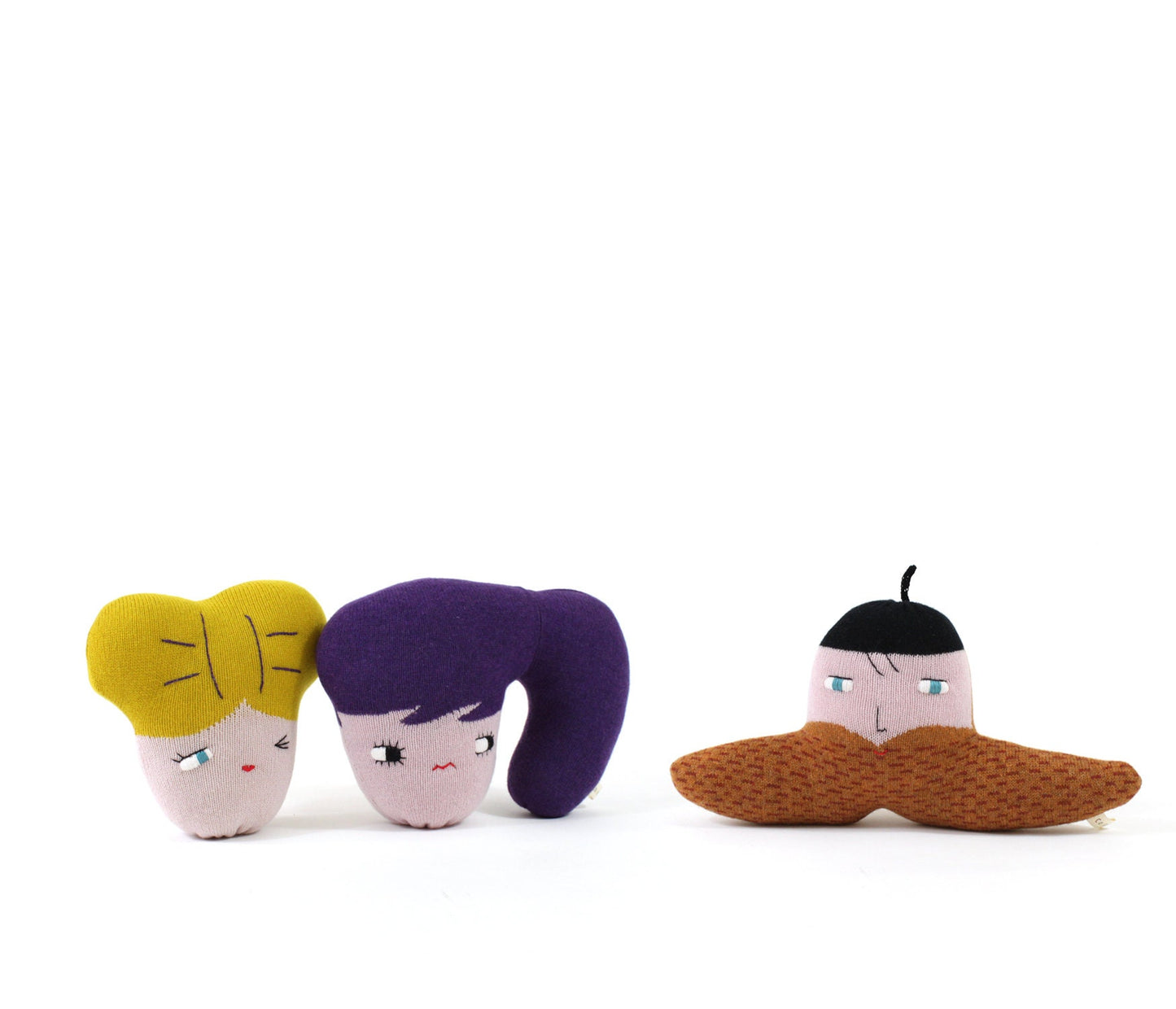 Three small plush toys with different hairstyles and facial expressions on a white background