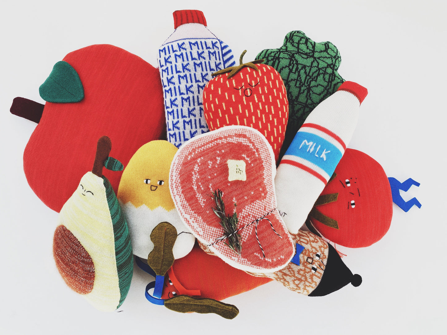 Colorful fabric toys shaped like fruits and vegetables on a white background