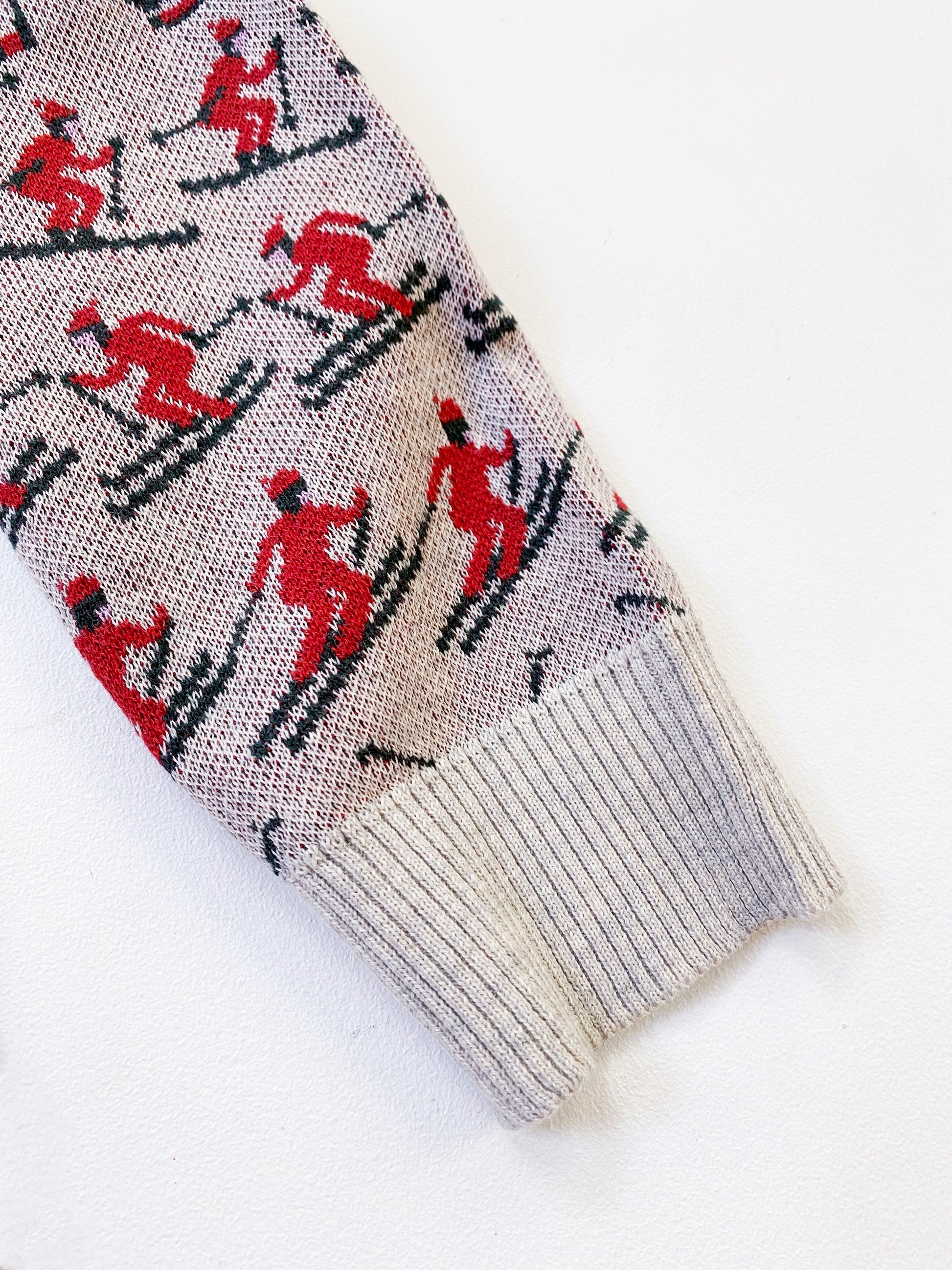 Knitted sweater with red and black skiers skiing pattern on a white background