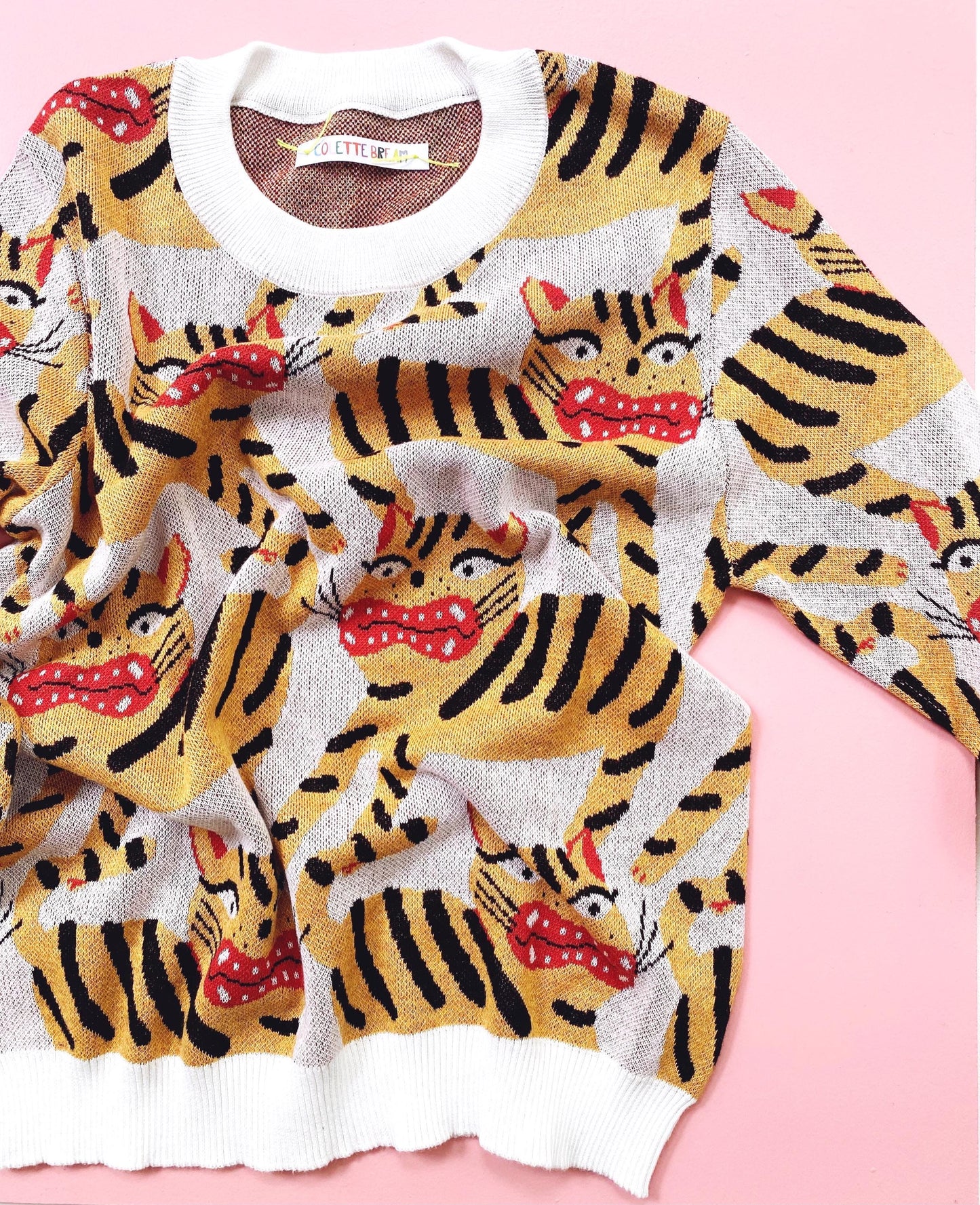 Knitted sweater with Hariko Tora tiger pattern on a pink background