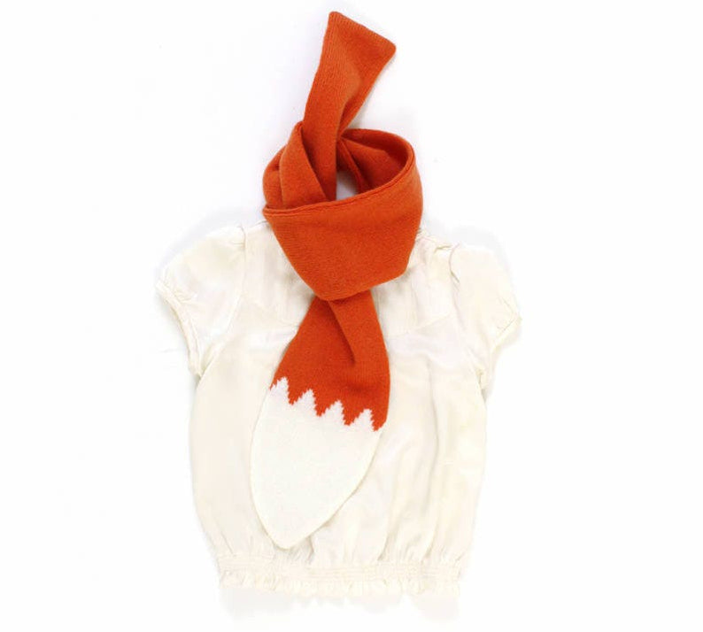 Orange scarf resembling a fox tail draped over a white sleeveless top on a white background