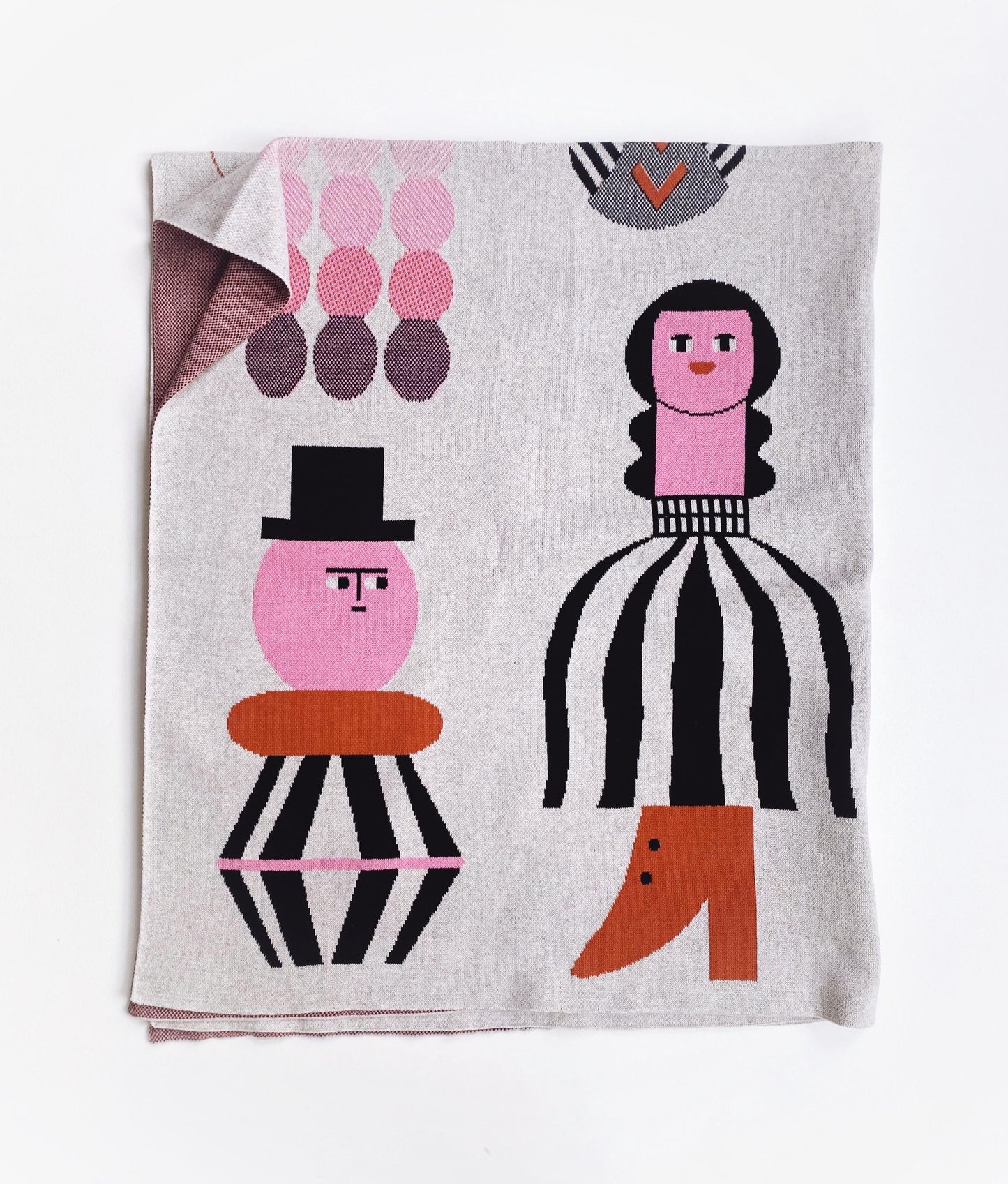 Knitted textile with abstract character design on a white background