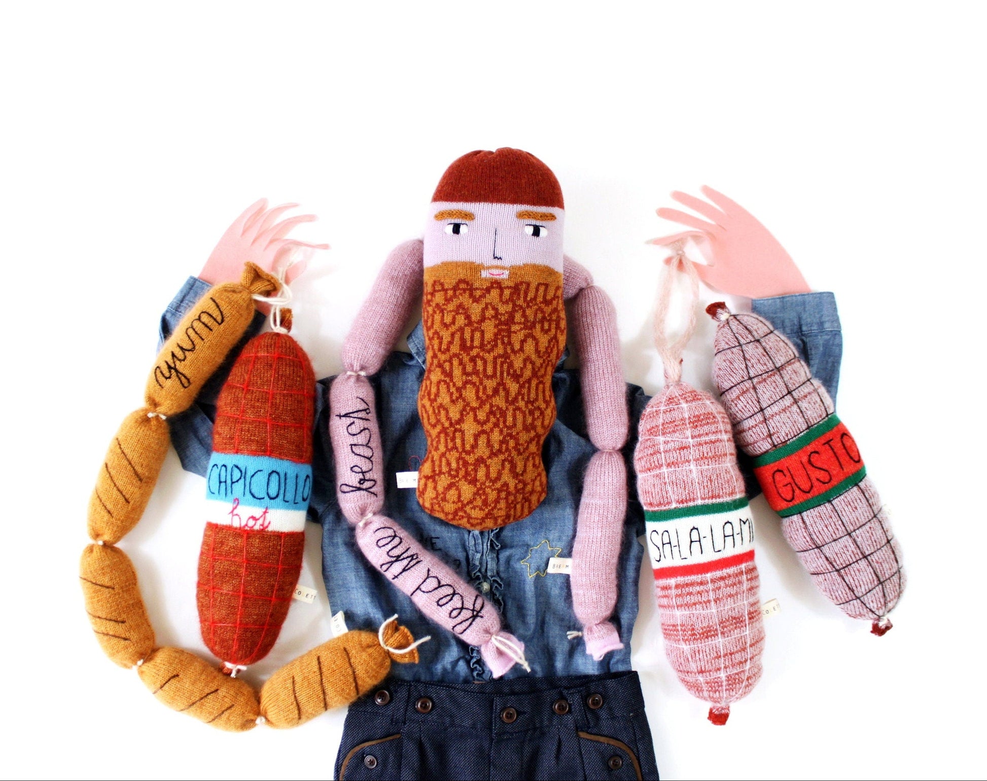 Textile knitted plush dolls with various accessories and clothing on a white background