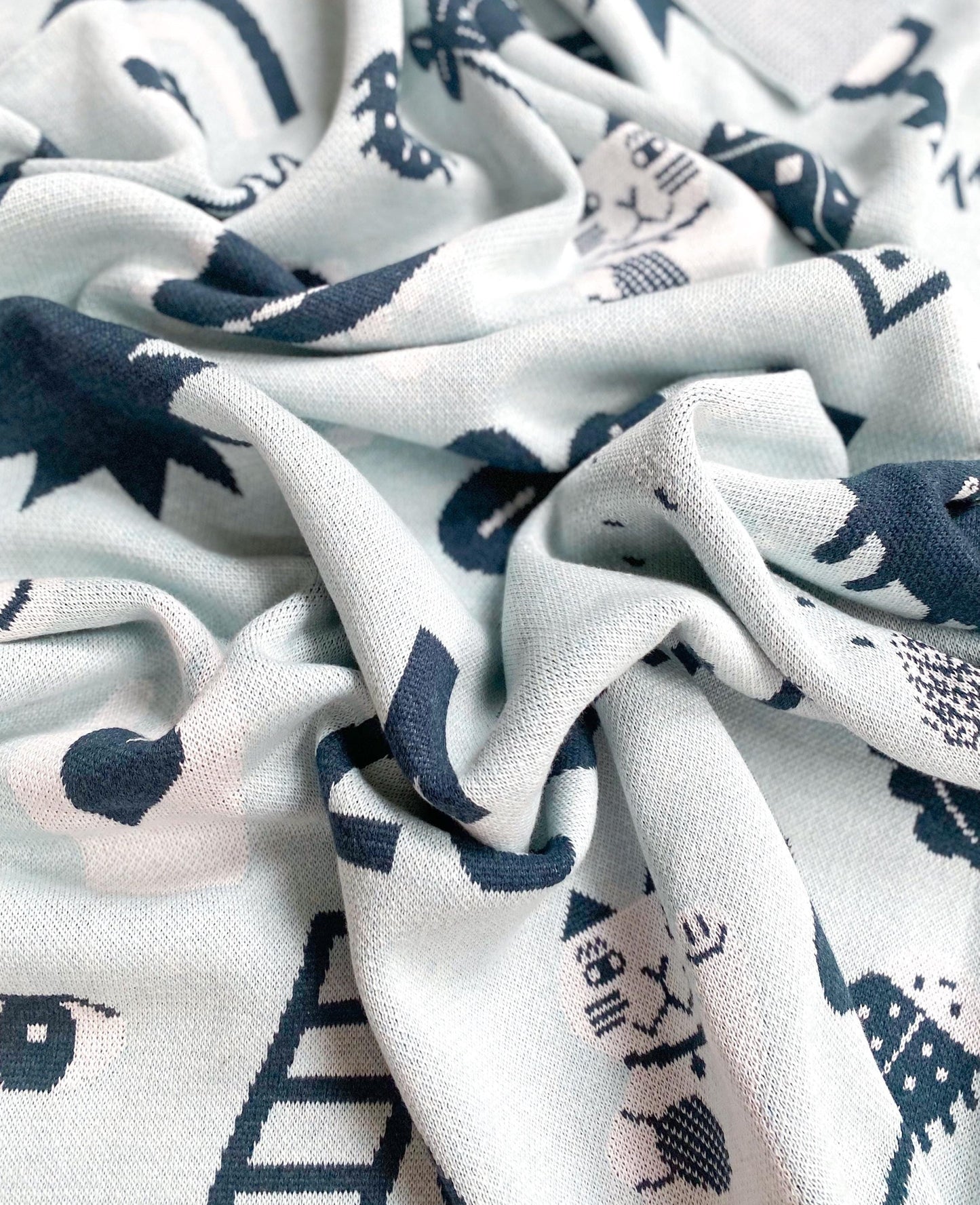 Close-up of knit fabric with blue and pink patterns on a white background