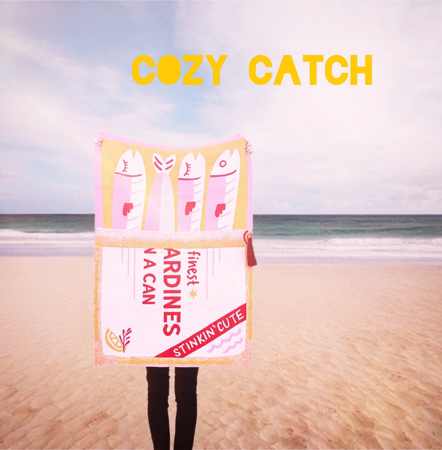 Person holding a 'Cozy Catch' knitted blanket product with a beach background