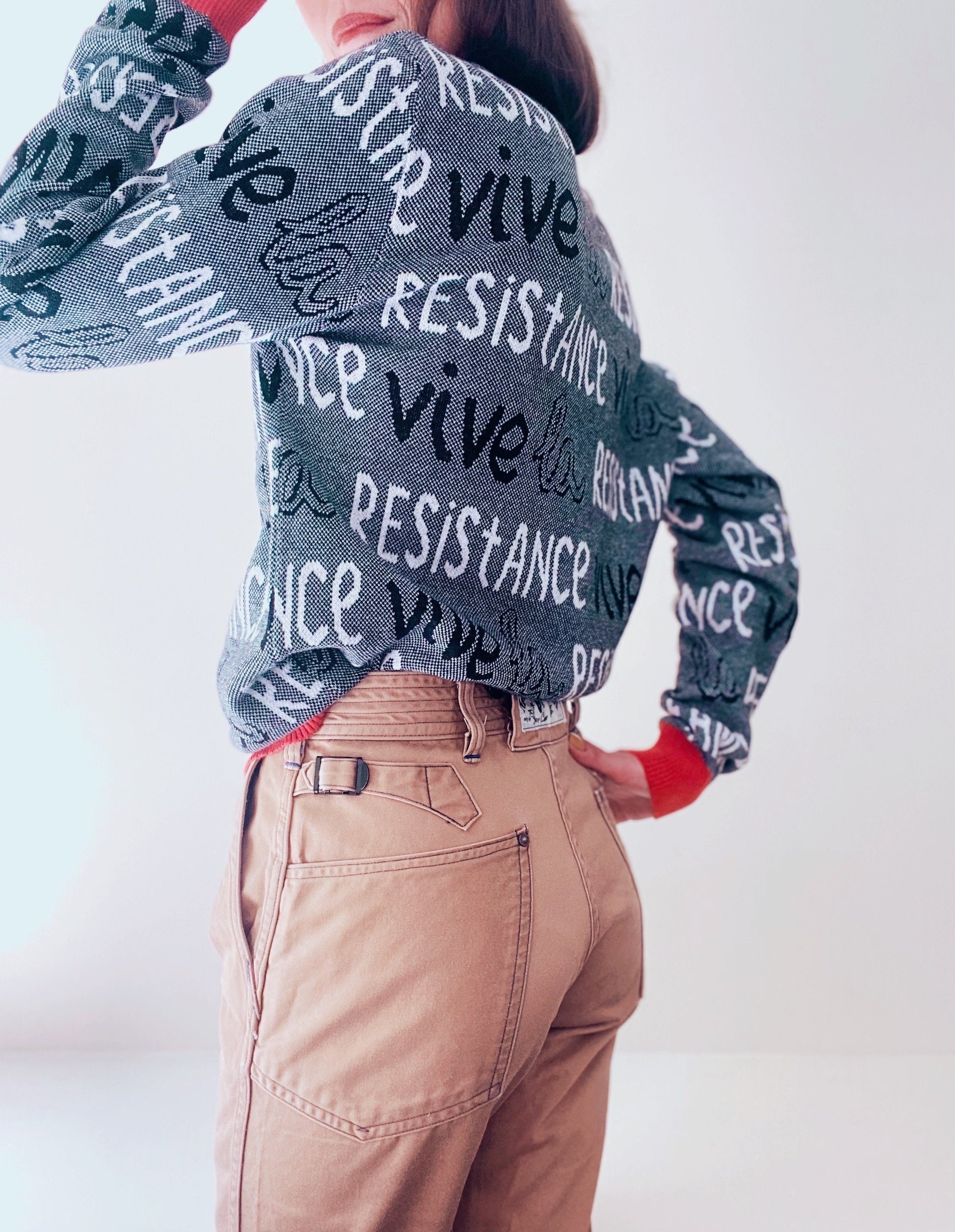 Person wearing a sweater with 'RESISTANCE' text on a white background