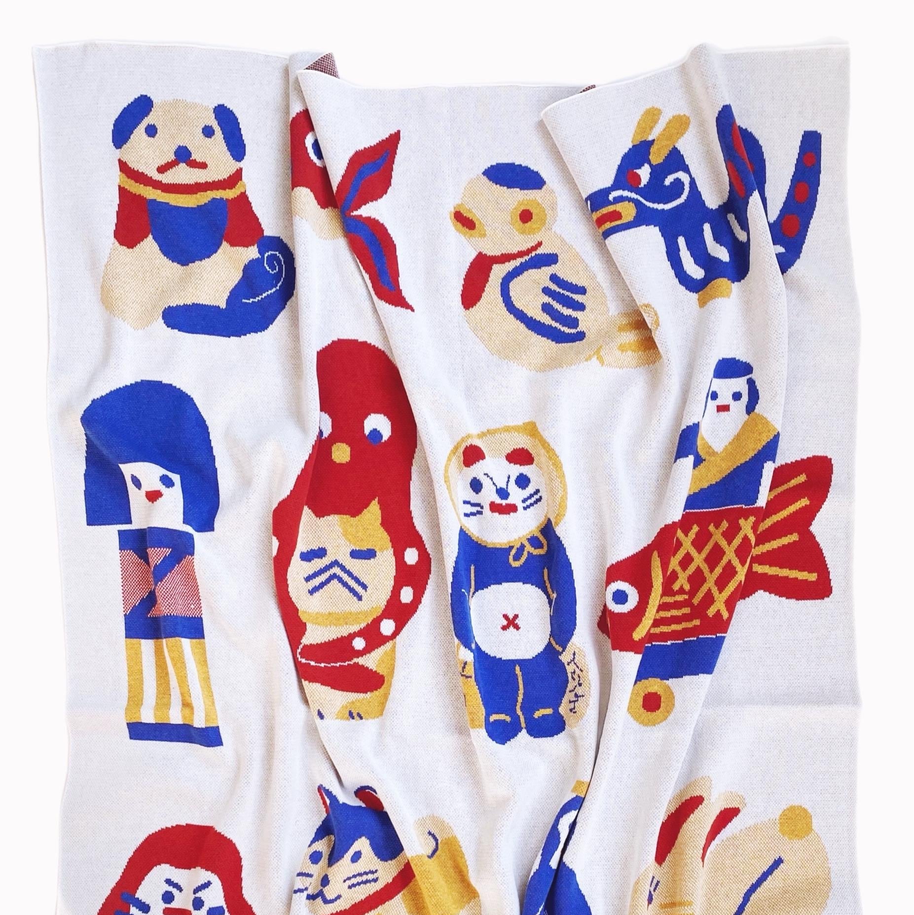 Knit blanket with colorful japanese animal characters designs on a white background