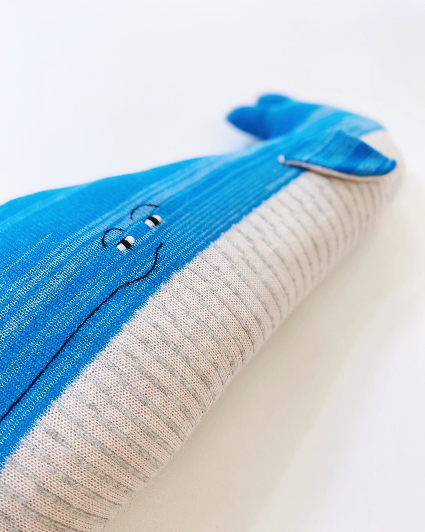 Detail of a knitted lambswool fabric with blue and gray pattern on a white background