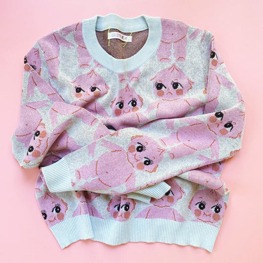 Pink sweater with kewpie doll pattern on a pink background