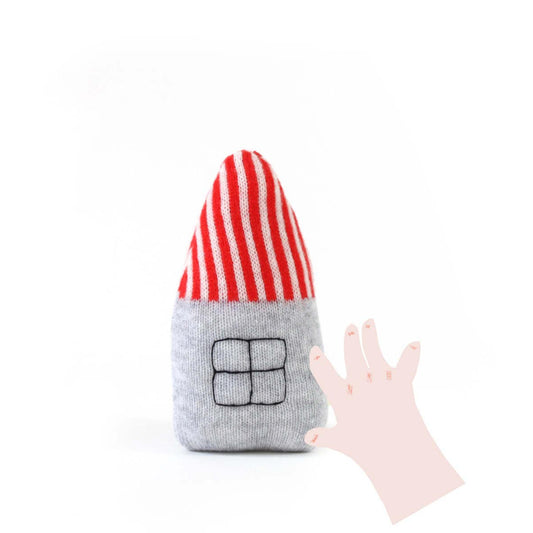 Toy resembling a house with a red and white striped roof and gray body on a white background