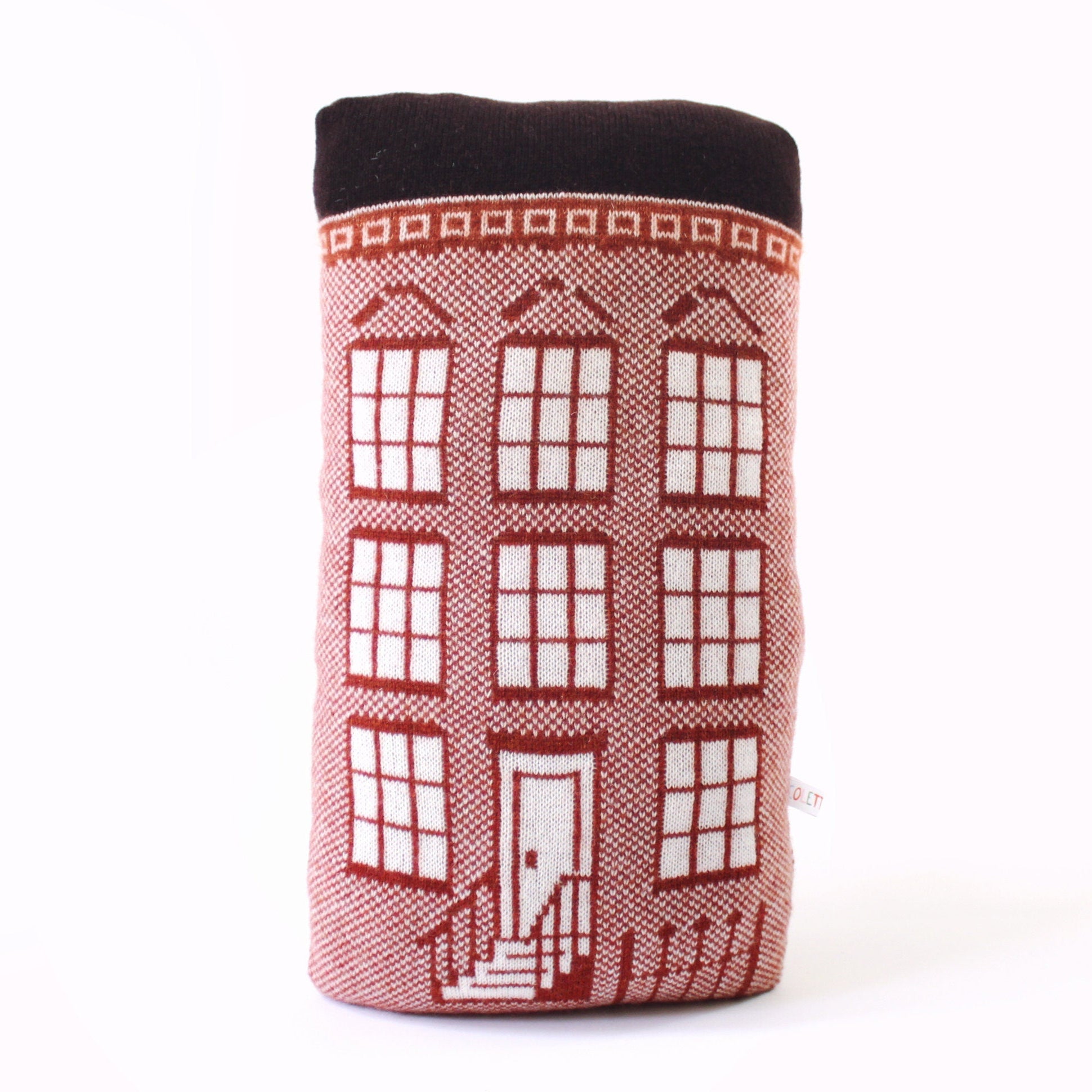Knitted lambswool pillow shaped like a brownstone house on a white background