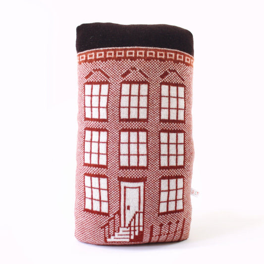 Knitted lambswool pillow shaped like a brownstone house on a white background