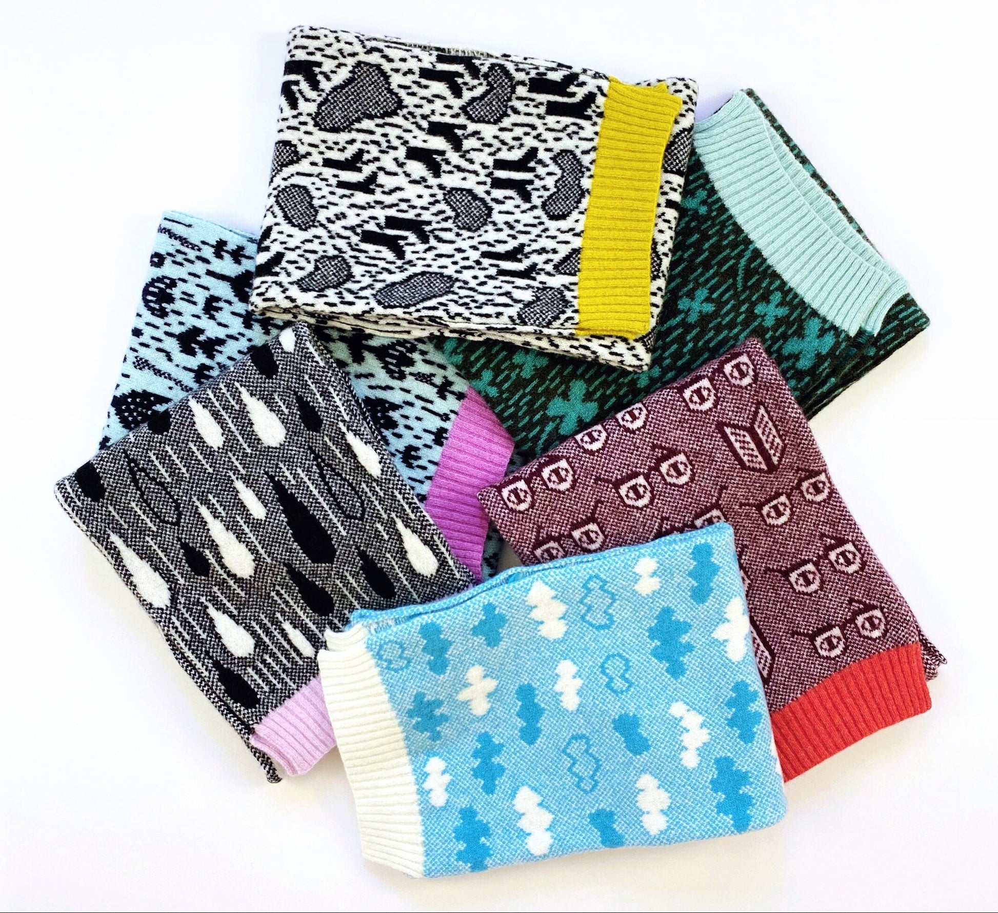Set of colorful knitted patterned scarves on a white background