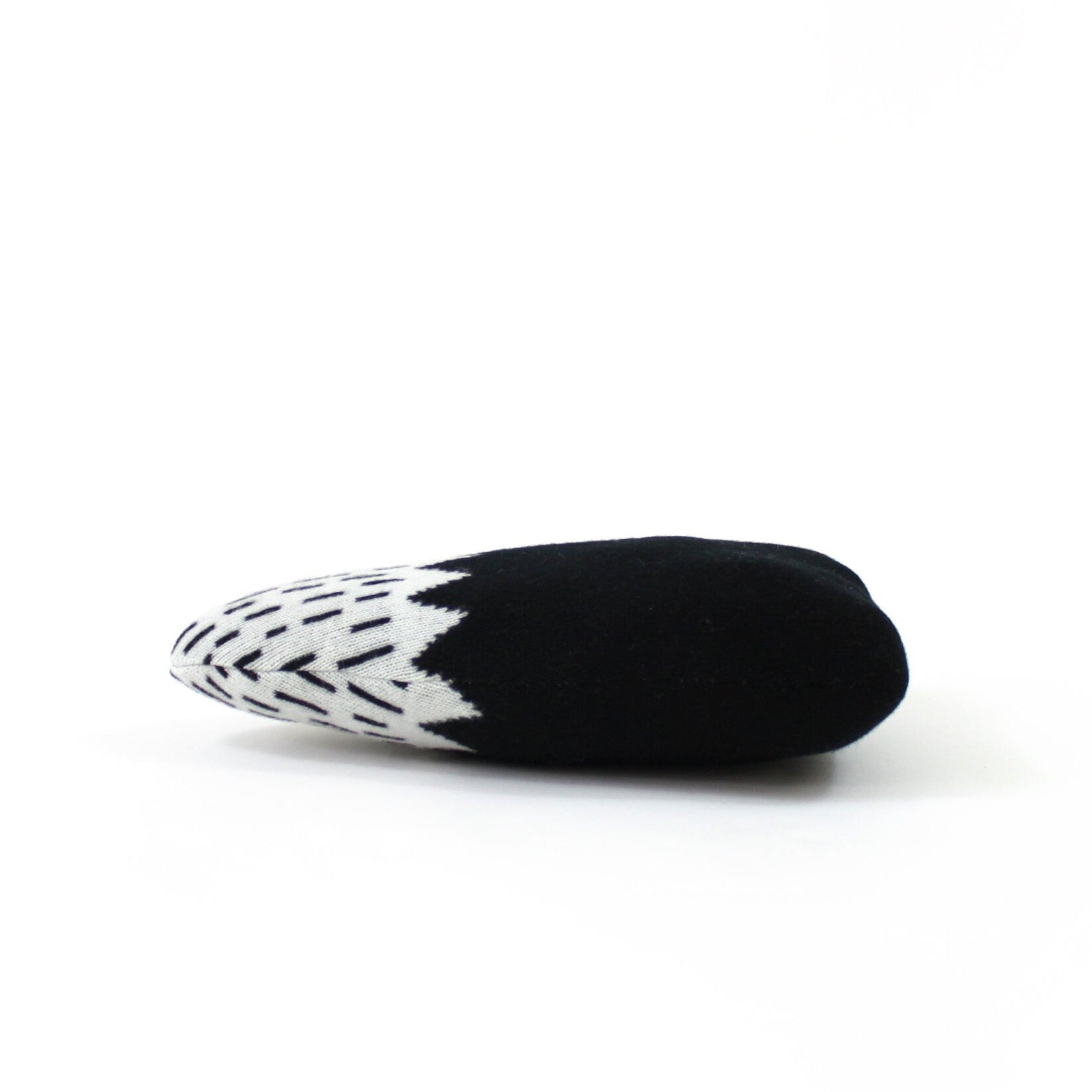 Black and white patterned mountain shaped pillow on a white background