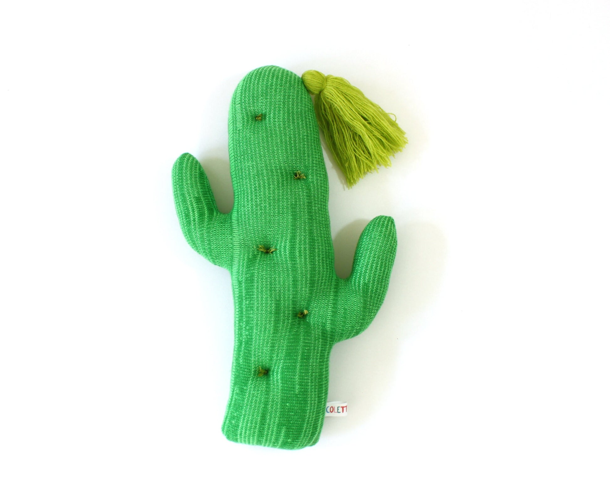 Green cactus-shaped toy with a yellow tassel on a white background
