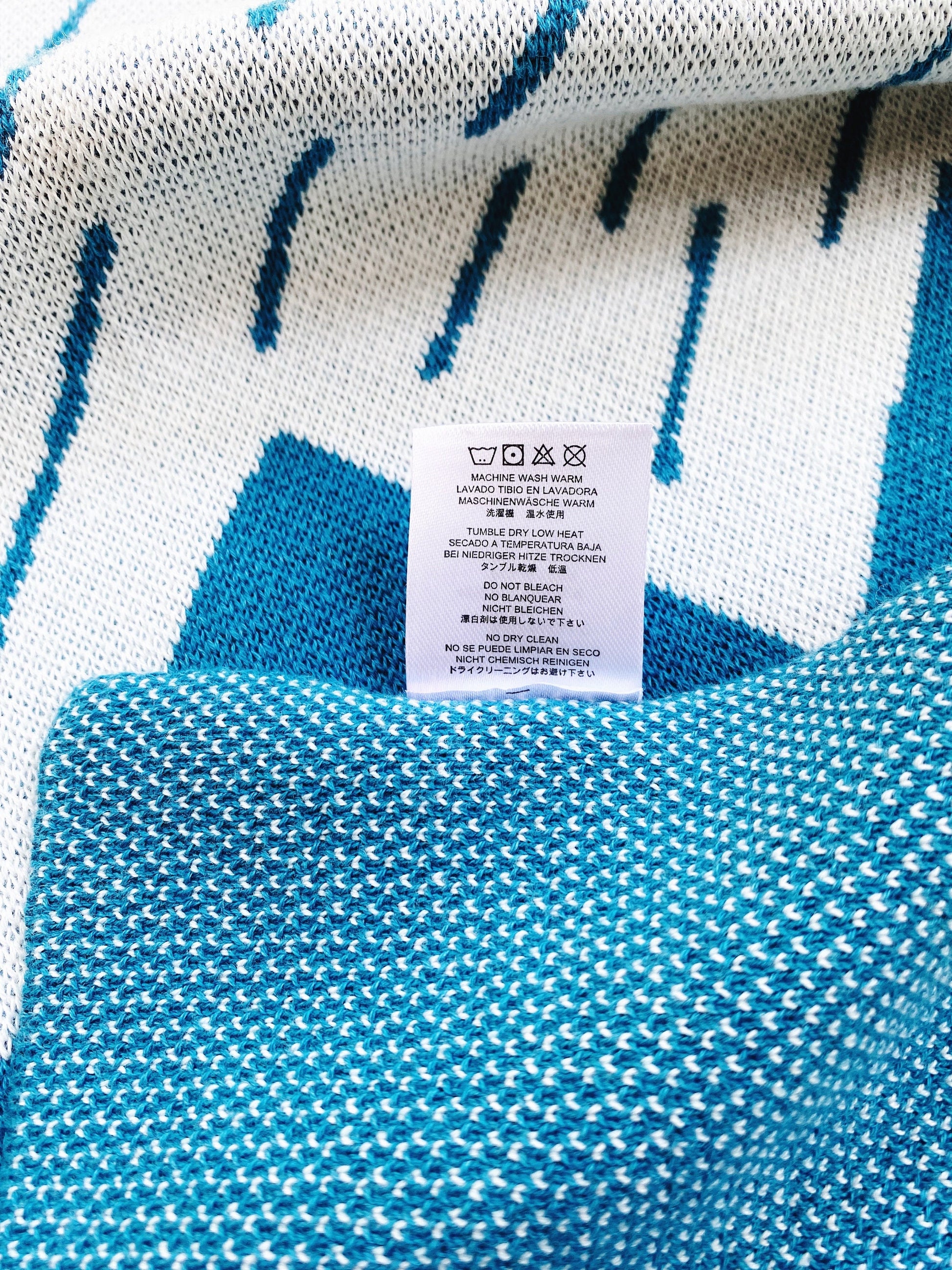 Close-up of a blue and white patterned knit fabric with a label on it.