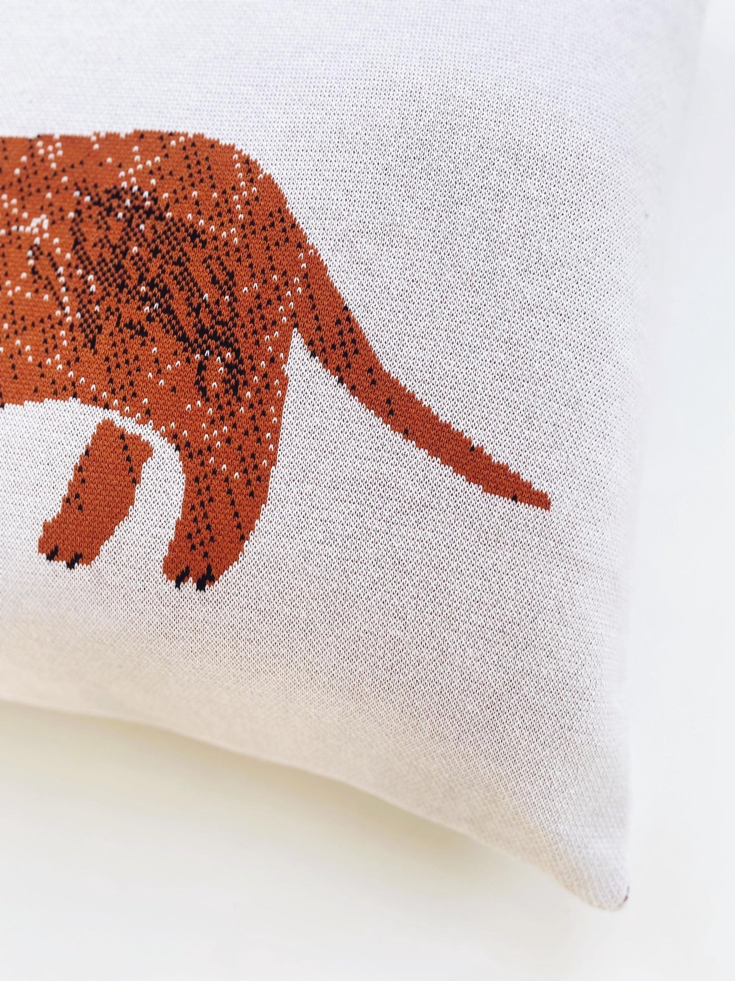 Decorative pillow with a brown sausage dog illustration on a white background