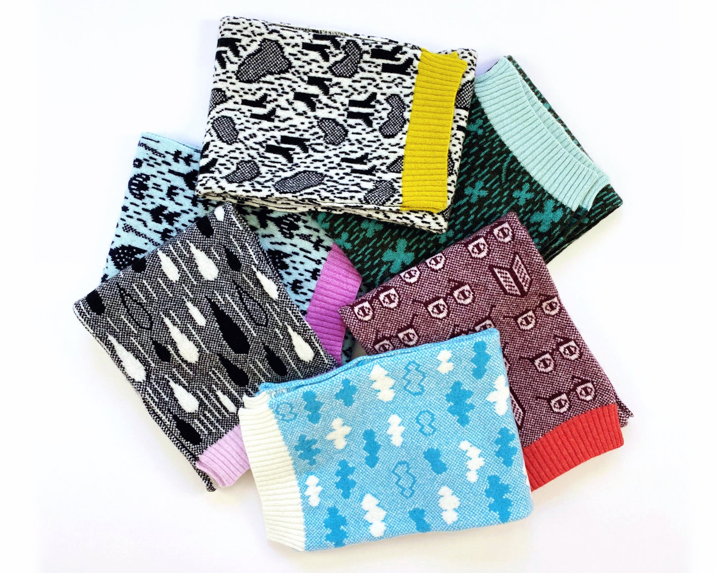 Set of colorful patterned knitted lambswool scarves on a white background
