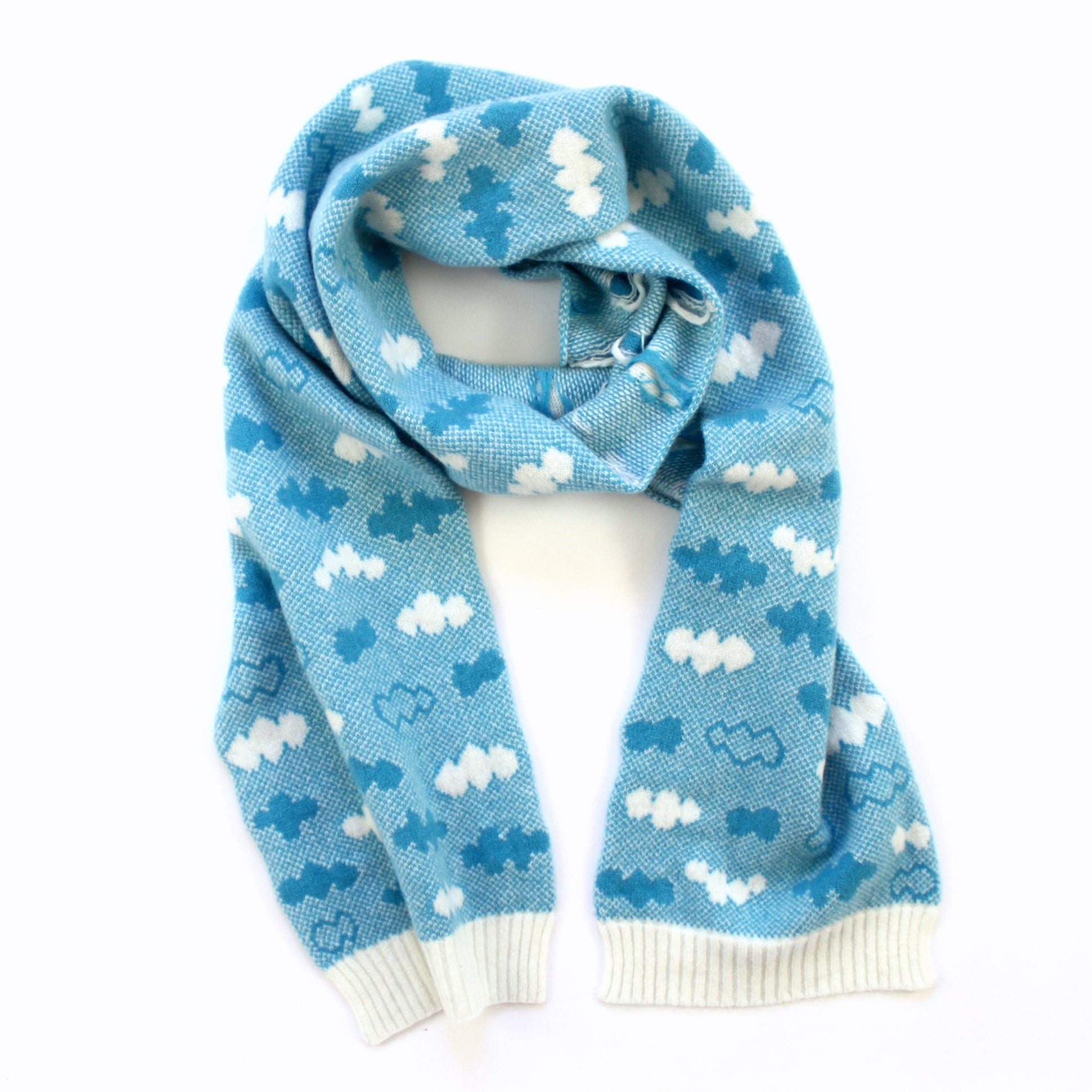 Blue knitted lambswool scarf with cloud pattern on a white background