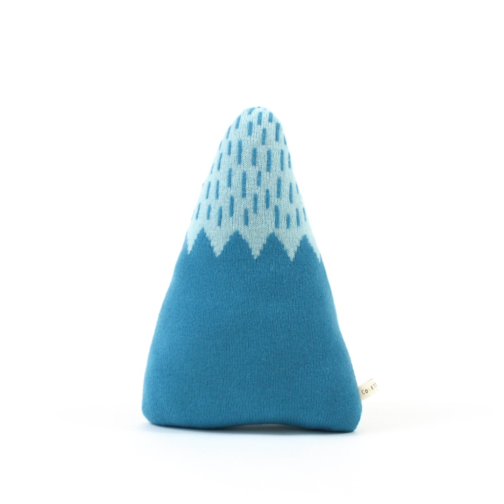 Blue mountain shaped cushion with white geometric pattern on a white background