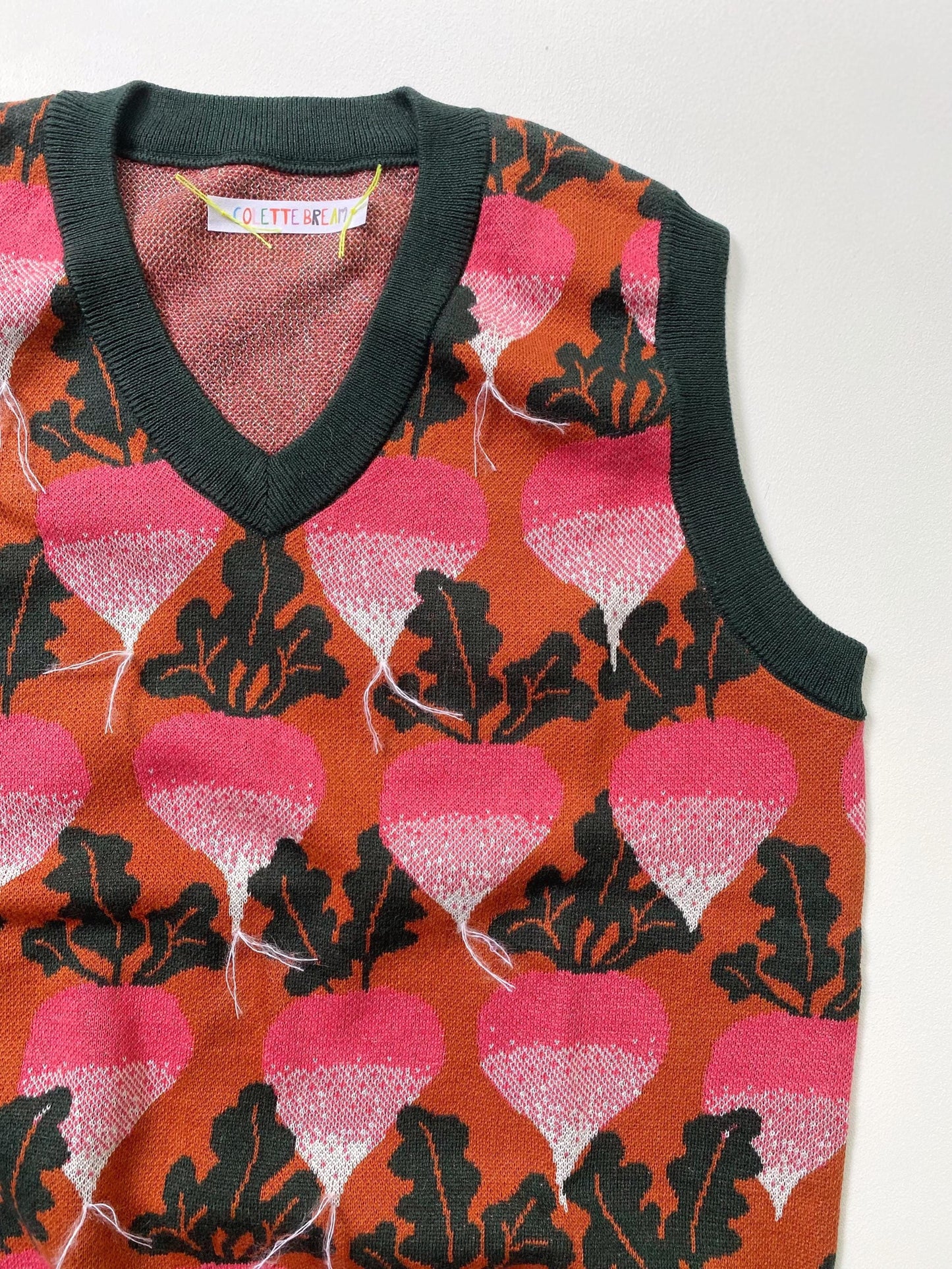 Sleeveless sweater vest with radish and beets pattern on a white background