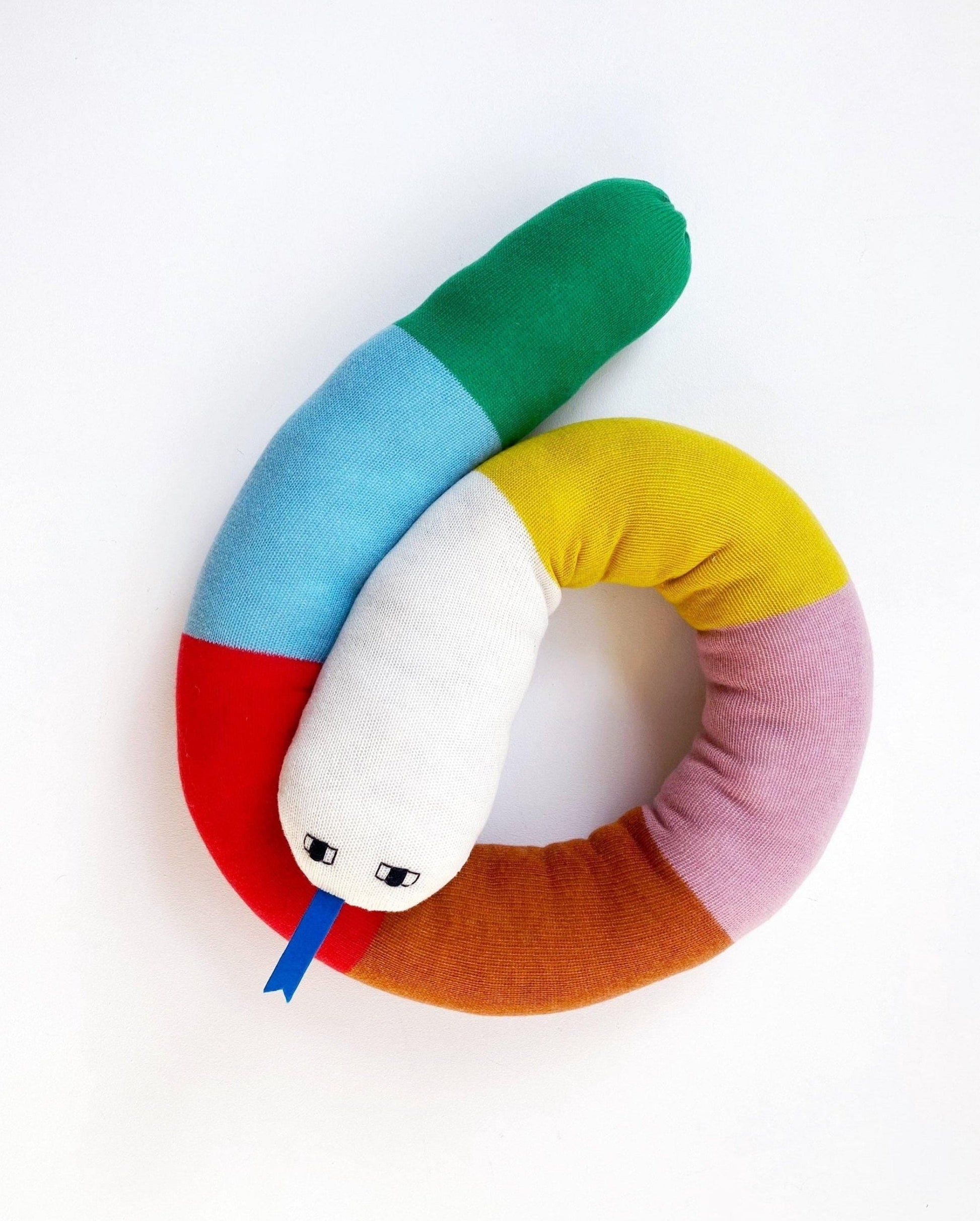 Colorful knitted snake-shaped pillow with a face on a white background