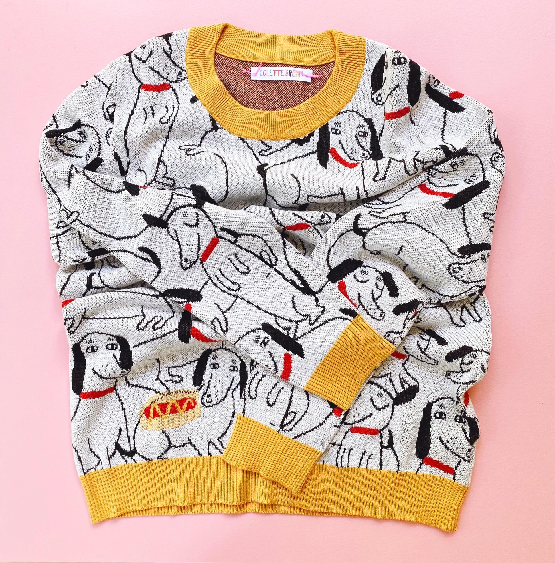 Knitted sweater with dachshund dog pattern on a pink background