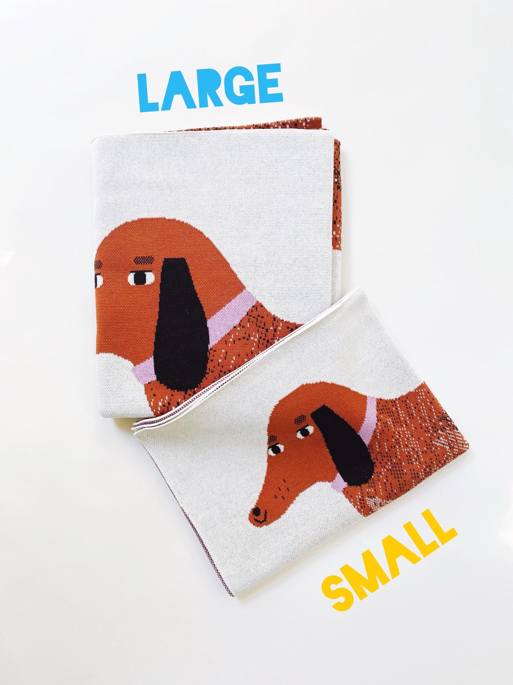 Two pairs of folded blankets with dachshund designs, labeled 'Large' and 'Small', on a white background.
