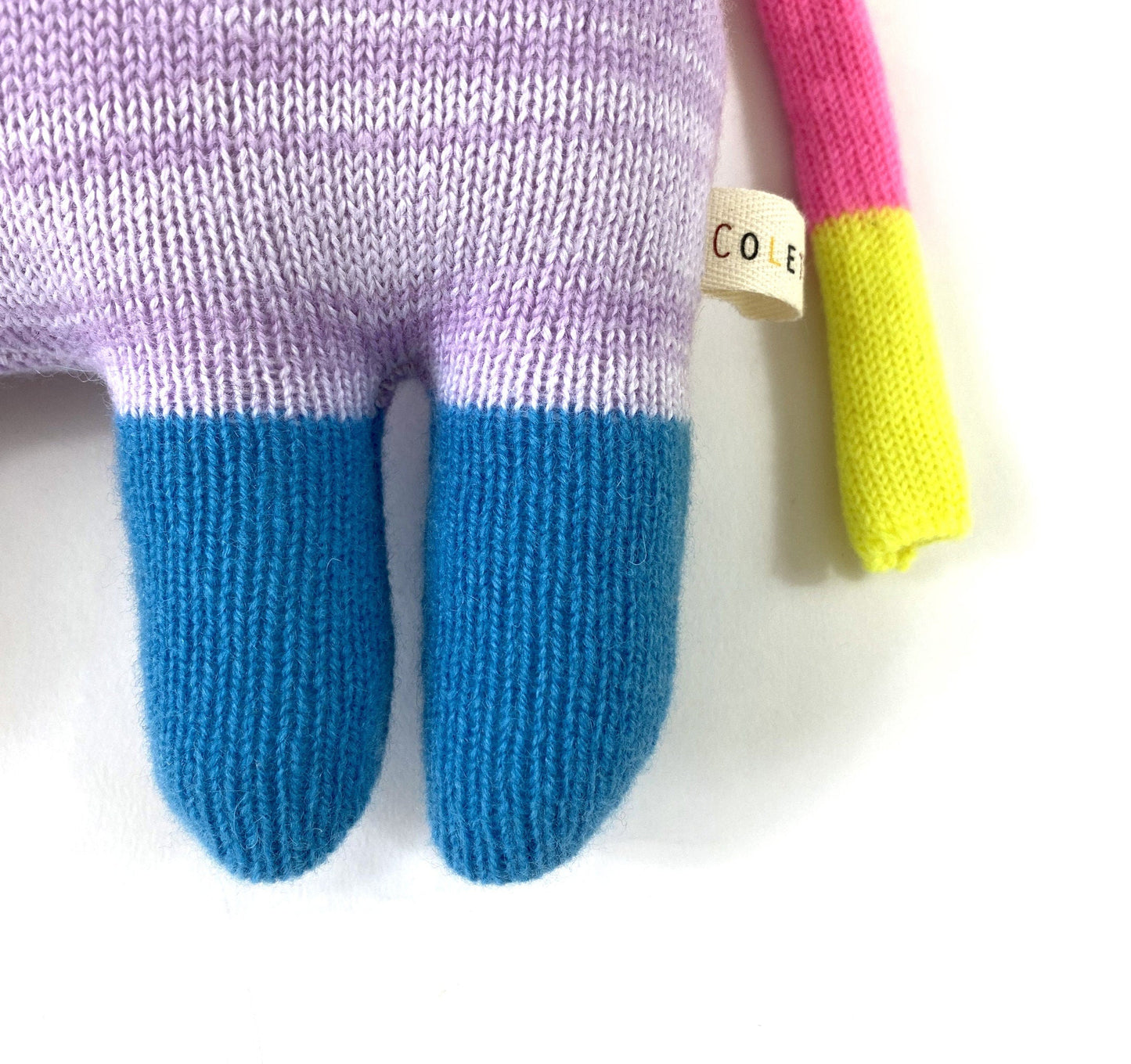 Colorful knitted toy with a tag on a white background