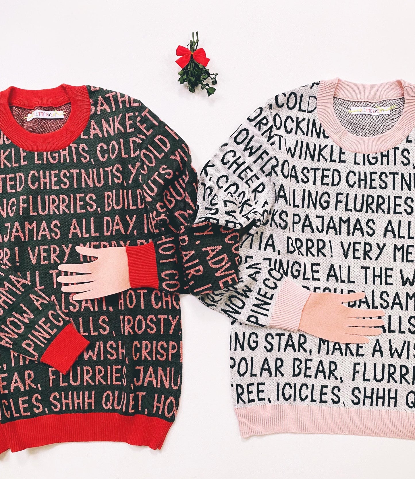 Two holiday sweaters with festive christmas text patterns on a white background