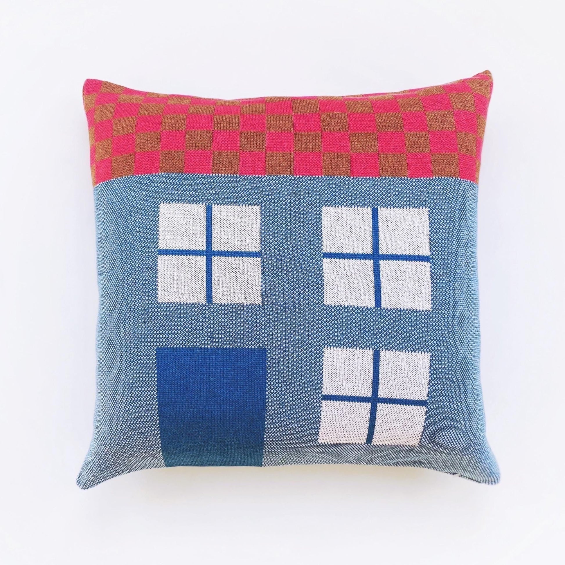 Decorative pillow with geometric house pattern on a white background