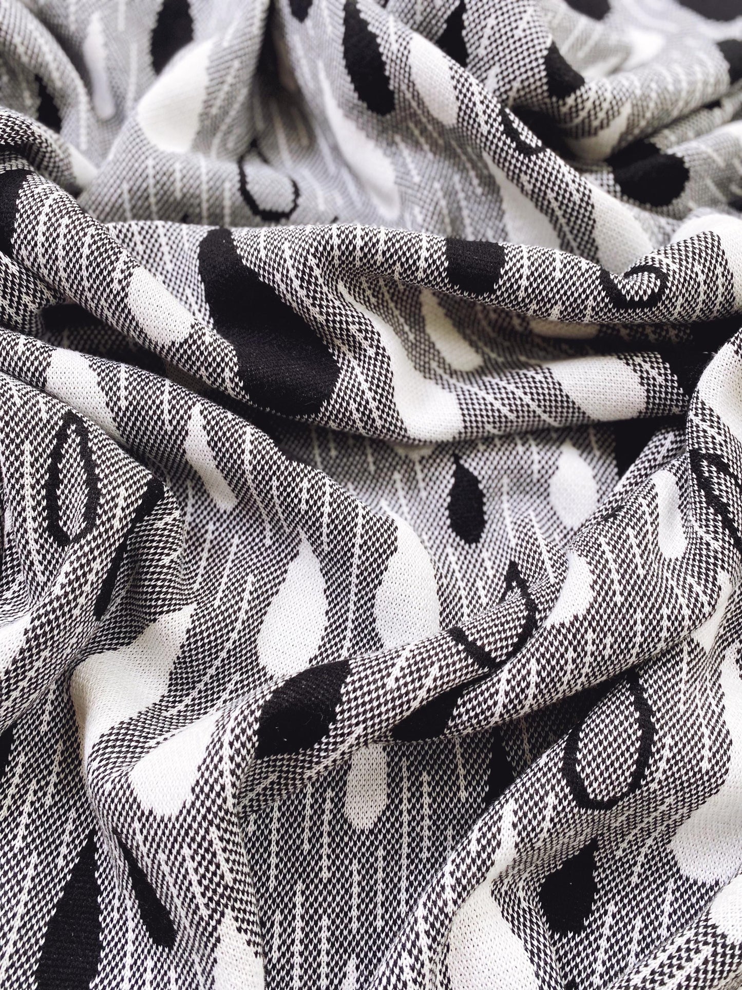 Close-up of a black and white raindrop patterned knitted fabric