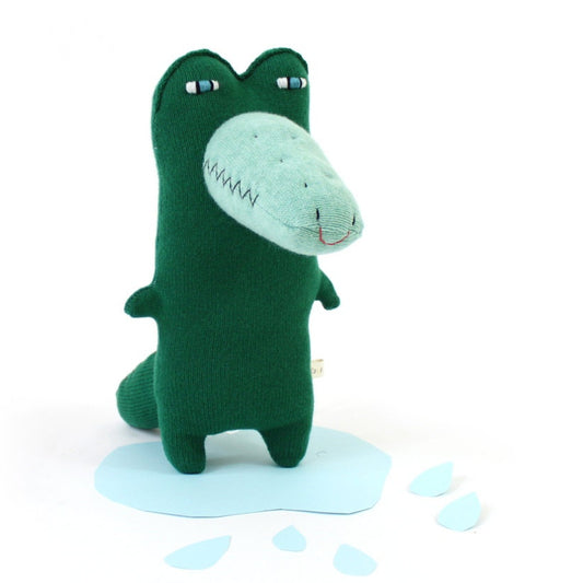 Green lambswool knitted plush toy resembling a crocodile with a smiling face on a white background