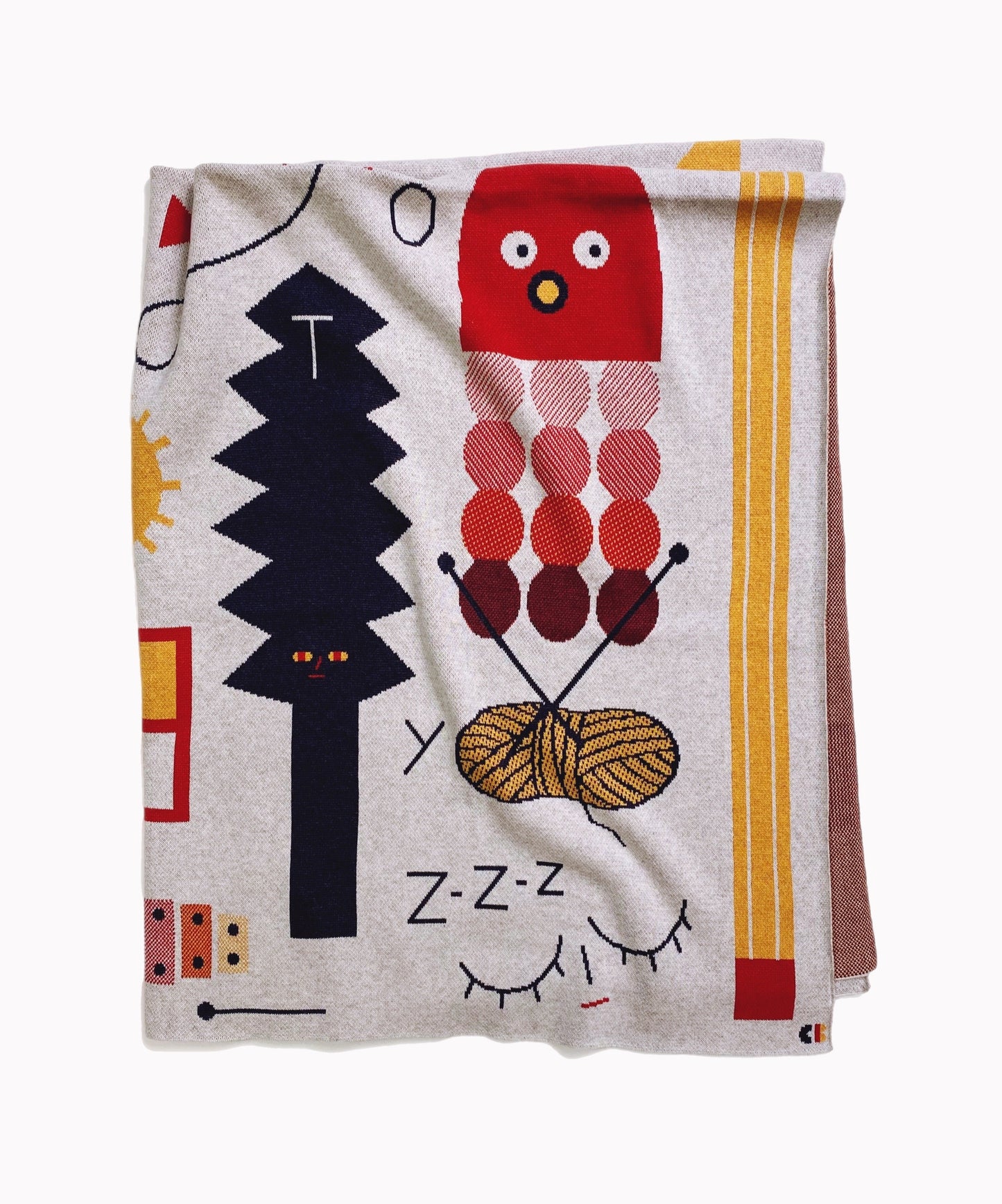 Folded knitted alphabet throw blanket with cartoon cat and yarn design on a white background