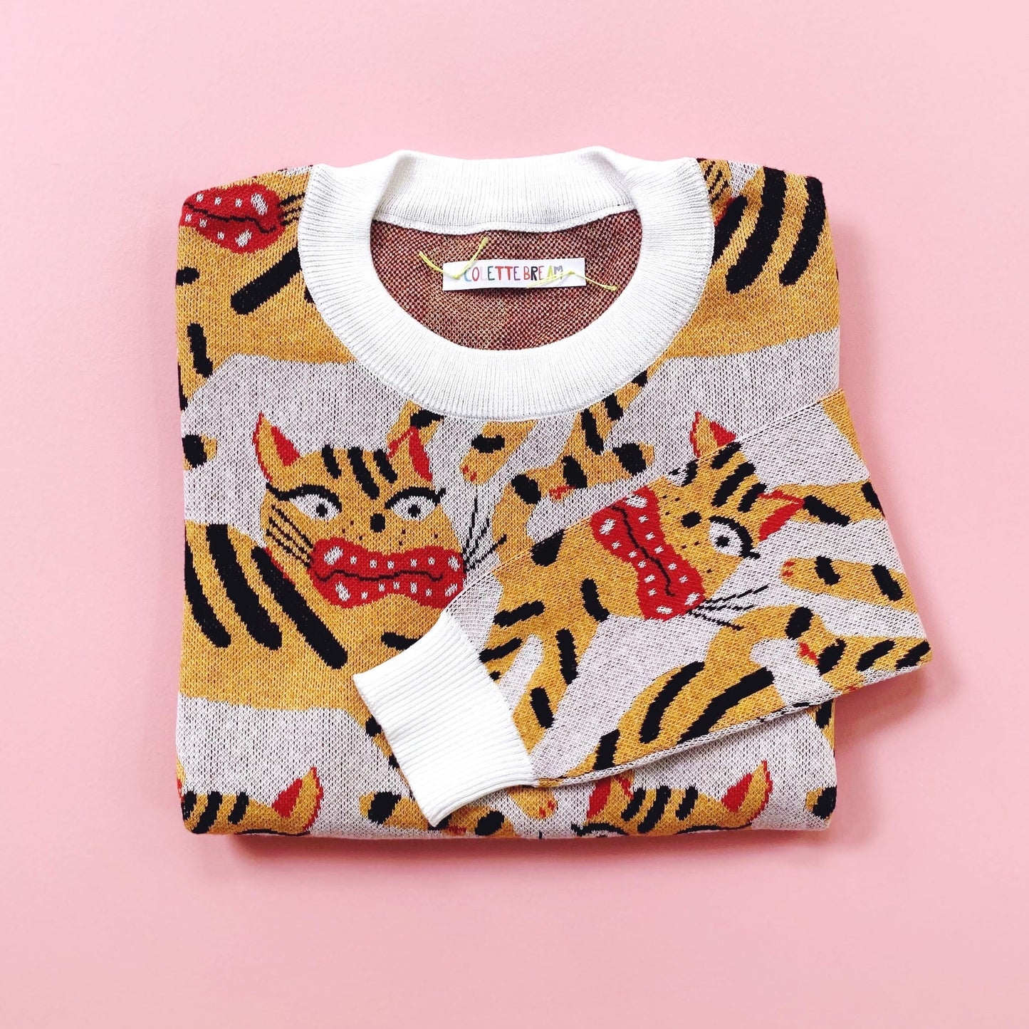 Folded sweater with Hariko Tora tiger pattern on a pink background