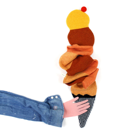 Colorful knitted lambswool scarf shaped like an ice cream with a hand holding it, on a white background